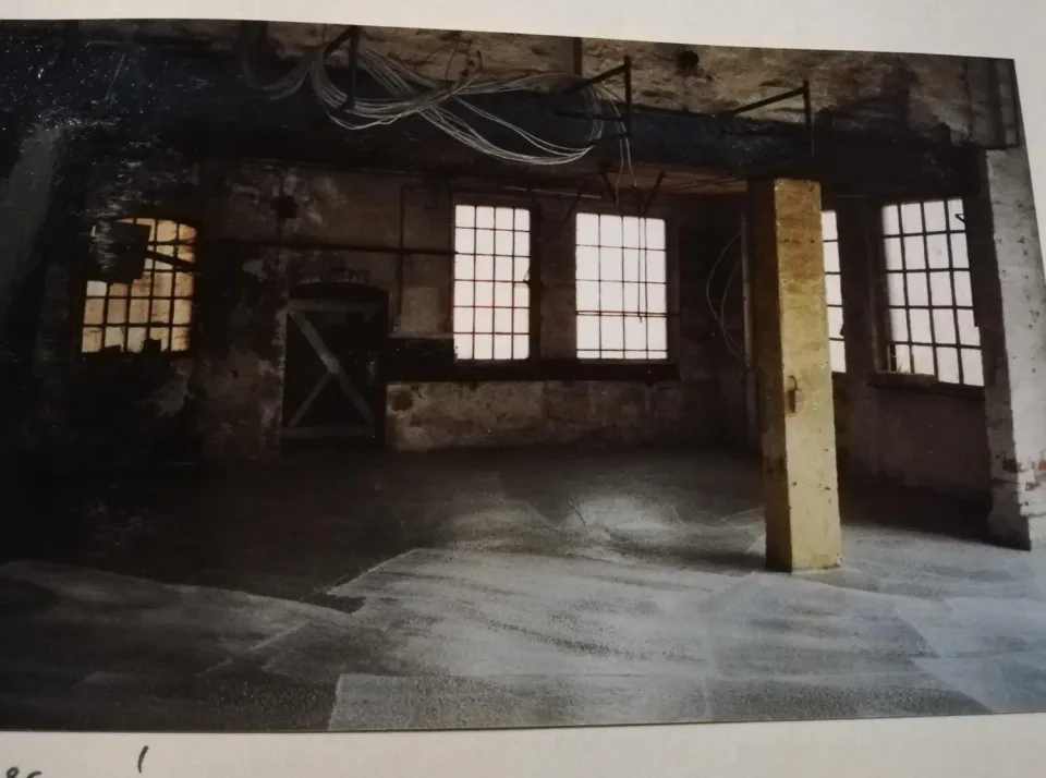 Studioraum mit hohen Fenstern und Industriecharakter